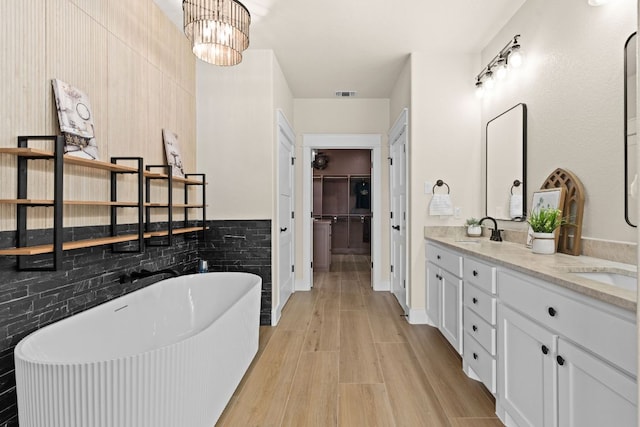 4374 Tall Rdg, Kempner, TX 76539 - full bath with double vanity, a soaking tub, wood finished floors, a chandelier, and tasteful backsplash