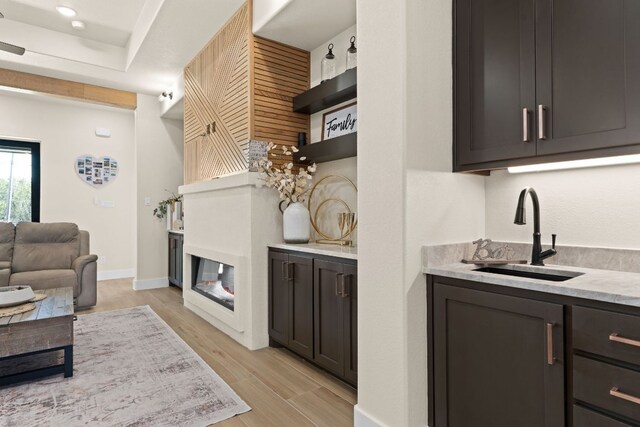 4374 Tall Rdg, Kempner, TX 76539 - bar with a sink, a glass covered fireplace, light wood finished floors, and baseboards