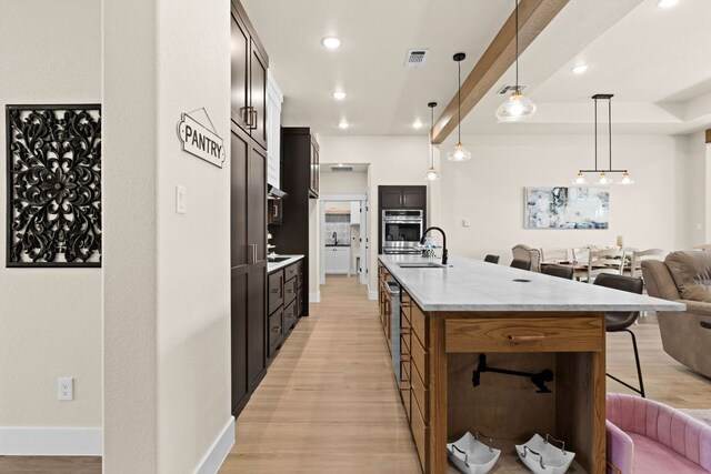 4374 Tall Rdg, Kempner, TX 76539 - kitchen with open floor plan, a kitchen bar, light wood finished floors, a center island with sink, and a sink