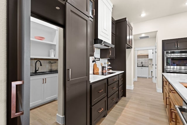 4374 Tall Rdg, Kempner, TX 76539 - kitchen featuring double oven, light wood-style flooring, tasteful backsplash, a sink, and open shelves