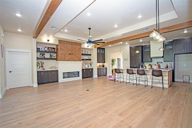 4374 Tall Rdg, Kempner, TX 76539 - kitchen featuring a tray ceiling, light countertops, a kitchen bar, ceiling fan, and tasteful backsplash