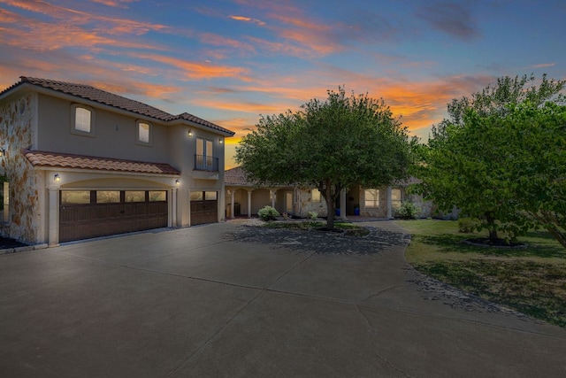 17308 Saint Therese Rd, Manor, TX 78653 - view of front of home featuring a garage, driveway, a tile roof, and stucco siding
