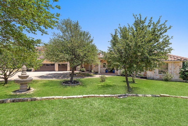 17308 Saint Therese Rd, Manor, TX 78653 - view of front facade with a front yard, a tile roof, stone siding, a garage, and driveway