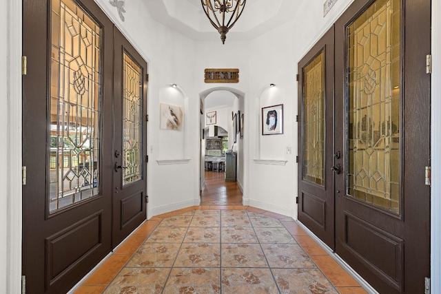 17308 Saint Therese Rd, Manor, TX 78653 - entryway featuring french doors, arched walkways, light tile patterned floors, and baseboards