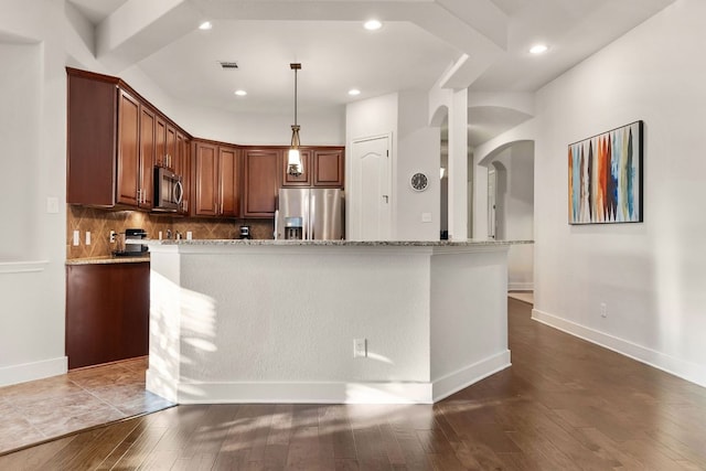 114 Fred Couples Dr, Round Rock, TX 78664 - kitchen with stainless steel appliances, arched walkways, decorative backsplash, dark wood-type flooring, and light stone counters