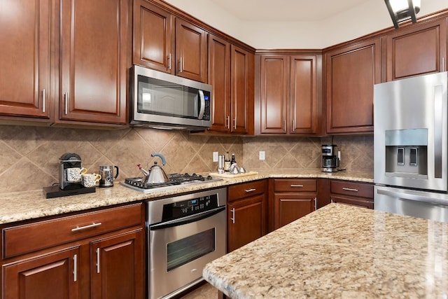 114 Fred Couples Dr, Round Rock, TX 78664 - kitchen with stainless steel appliances, tasteful backsplash, and light stone countertops