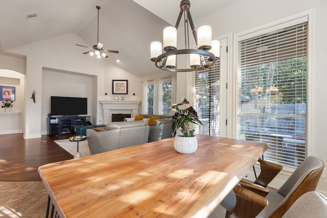 114 Fred Couples Dr, Round Rock, TX 78664 - dining room with ceiling fan, a chandelier, a fireplace, baseboards, and high vaulted ceiling