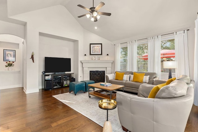 114 Fred Couples Dr, Round Rock, TX 78664 - living room featuring dark wood-style flooring, ceiling fan, arched walkways, a fireplace, and high vaulted ceiling