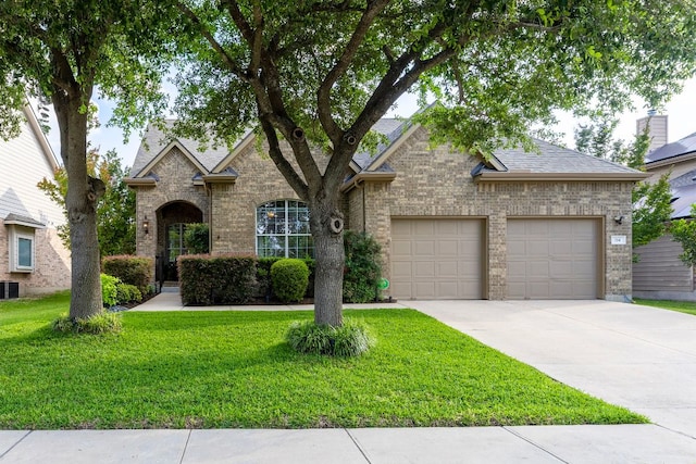 114 Fred Couples Dr, Round Rock, TX 78664 - view of front of home featuring an attached garage, driveway, a front yard, and brick siding