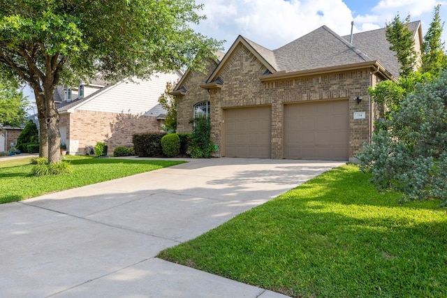 114 Fred Couples Dr, Round Rock, TX 78664 - view of front of property with an attached garage, concrete driveway, brick siding, a front yard, and a shingled roof