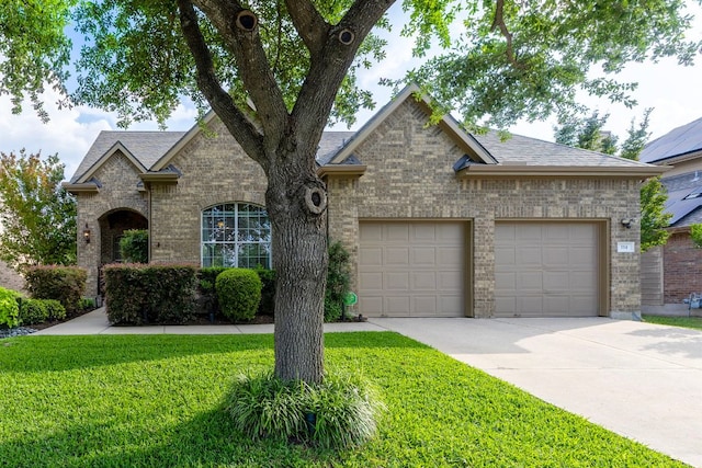 114 Fred Couples Dr, Round Rock, TX 78664 - view of front facade with concrete driveway, an attached garage, a front yard, and brick siding