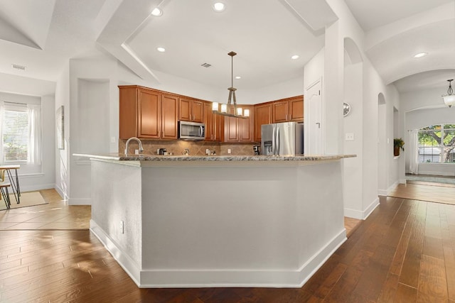 114 Fred Couples Dr, Round Rock, TX 78664 - kitchen featuring appliances with stainless steel finishes, baseboards, backsplash, light stone countertops, and dark wood finished floors