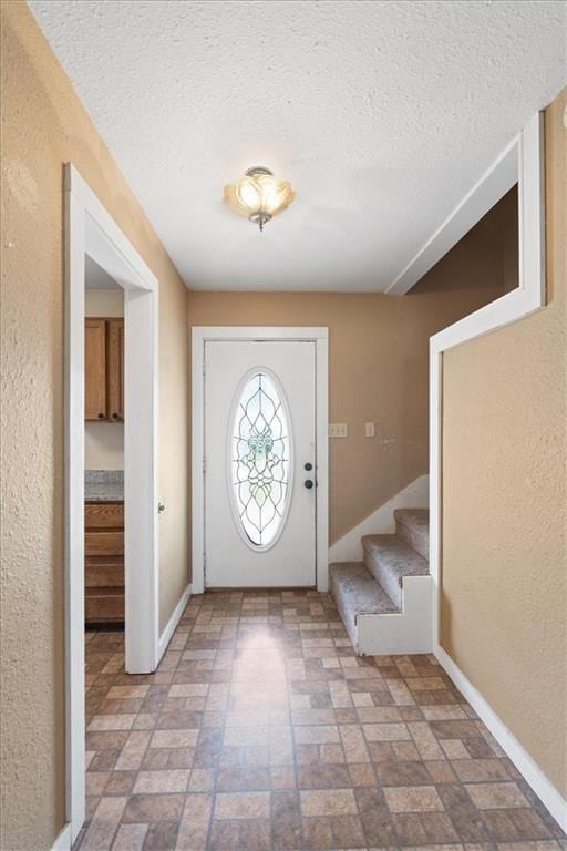 461 Skyline Rdg, San Marcos, TX 78666 - entrance foyer with stairway, brick patterned flooring, a textured ceiling, and baseboards