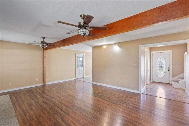 461 Skyline Rdg, San Marcos, TX 78666 - unfurnished living room with a ceiling fan, wood finished floors, beam ceiling, baseboards, and stairway