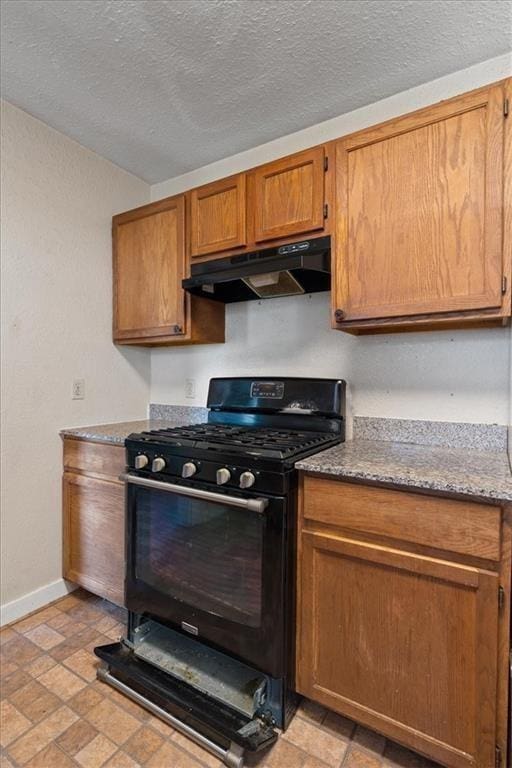 461 Skyline Rdg, San Marcos, TX 78666 - kitchen with black gas range, under cabinet range hood, baseboards, brown cabinets, and stone countertops
