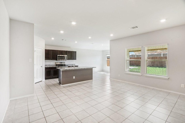 9701 Kensley Rose Dr, Killeen, TX 76542 - kitchen with stainless steel appliances, open floor plan, a kitchen island with sink, recessed lighting, and baseboards