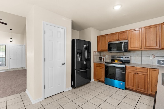 10 Saul St, Lampasas, TX 76550 - kitchen with stainless steel appliances, light tile patterned floors, tasteful backsplash, and brown cabinetry