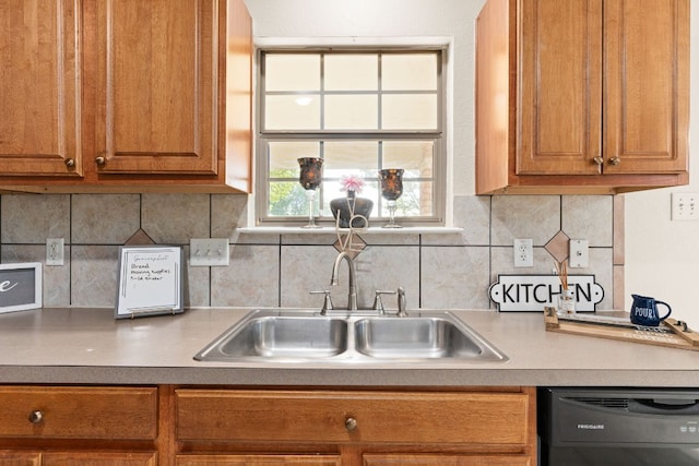 10 Saul St, Lampasas, TX 76550 - kitchen with dishwasher, a sink, brown cabinets, and decorative backsplash