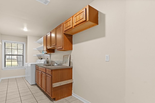 10 Saul St, Lampasas, TX 76550 - kitchen featuring light tile patterned floors, independent washer and dryer, open shelves, light countertops, and brown cabinetry