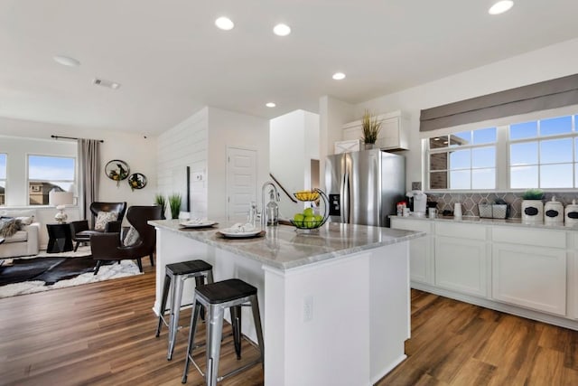 8169 Daisy Cutter Xing, Georgetown, TX 78626 - kitchen with stainless steel fridge with ice dispenser, a kitchen breakfast bar, light stone countertops, healthy amount of natural light, and recessed lighting