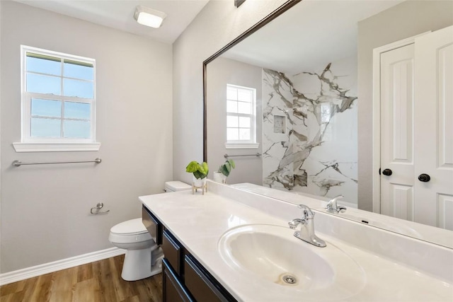1145 Lago Vista St, San Marcos, TX 78666 - full bathroom featuring toilet, vanity, a marble finish shower, baseboards, and wood finished floors