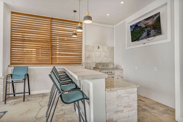 127 Cypress Shores Ln, Kingsland, TX 78639 - kitchen with concrete floors, pendant lighting, a breakfast bar area, decorative backsplash, and recessed lighting