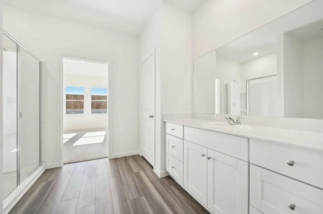 1504 Morris Loop, San Marcos, TX 78666 - bathroom with vanity, wood finished floors, and a stall shower