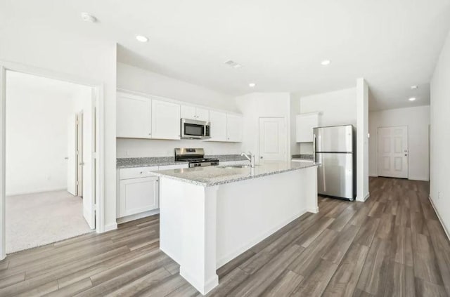 1504 Morris Loop, San Marcos, TX 78666 - kitchen featuring stainless steel appliances, a sink, white cabinetry, wood finished floors, and recessed lighting