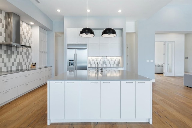 7816 Lynchburg Dr, Austin, TX 78738 - kitchen featuring built in refrigerator, wall chimney exhaust hood, decorative backsplash, black electric stovetop, and recessed lighting
