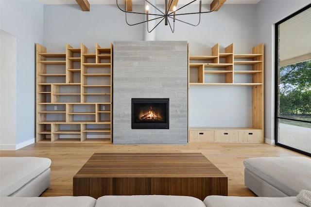 7816 Lynchburg Dr, Austin, TX 78738 - living room featuring wood finished floors, baseboards, a fireplace, and a chandelier