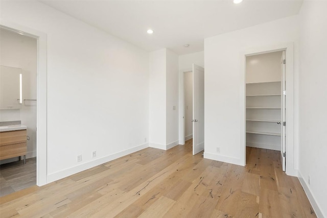 7816 Lynchburg Dr, Austin, TX 78738 - unfurnished bedroom with a spacious closet, light wood-type flooring, a closet, baseboards, and recessed lighting