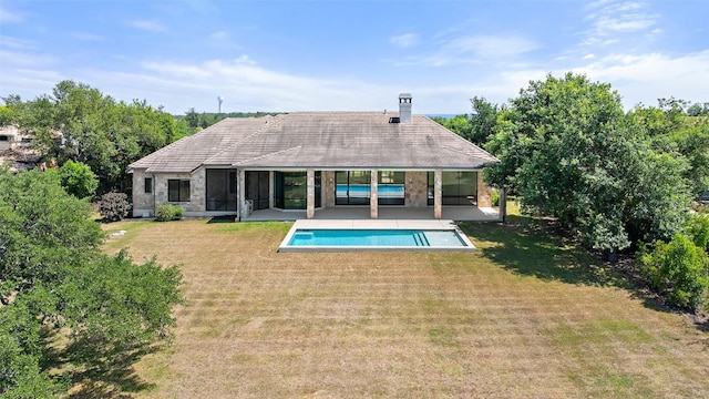 7816 Lynchburg Dr, Austin, TX 78738 - back of house with a lawn, an outdoor pool, a chimney, a patio, and a sunroom