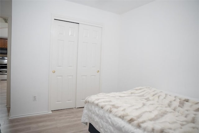 9305 Pioneer Forest Dr, Austin, TX 78744 - bedroom featuring light wood finished floors and a closet