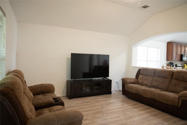 9305 Pioneer Forest Dr, Austin, TX 78744 - living area with light wood-style flooring, arched walkways, lofted ceiling, and baseboards