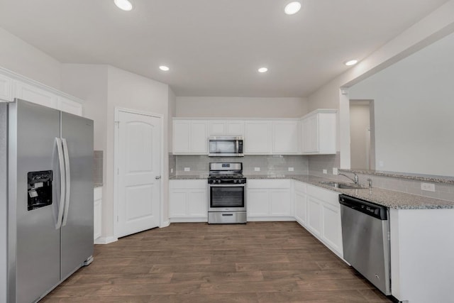 2900 Tweedy Trl, Pflugerville, TX 78660 - kitchen with appliances with stainless steel finishes, backsplash, white cabinets, and recessed lighting