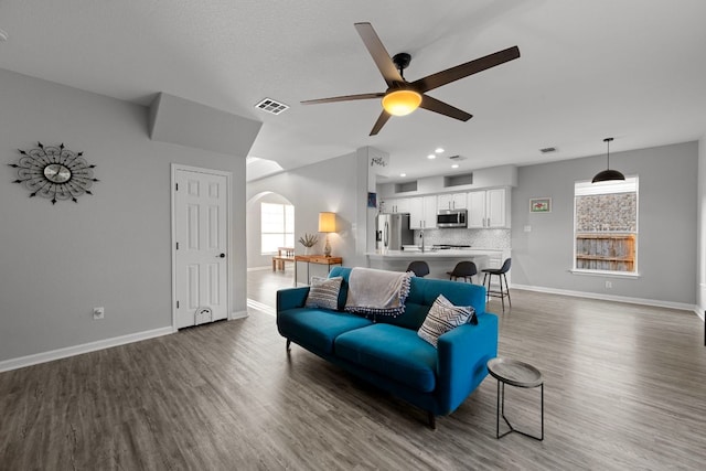 2208 Barnett Dr, Cedar Park, TX 78613 - living room with arched walkways, baseboards, ceiling fan, wood finished floors, and recessed lighting