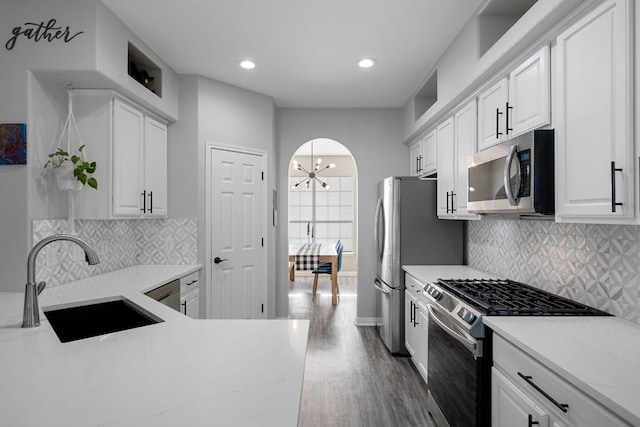 2208 Barnett Dr, Cedar Park, TX 78613 - kitchen featuring stainless steel appliances, a sink, dark wood-style flooring, white cabinets, and a chandelier