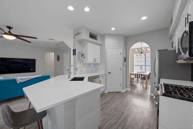 2208 Barnett Dr, Cedar Park, TX 78613 - kitchen with a sink, appliances with stainless steel finishes, a peninsula, white cabinets, and a chandelier