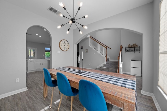 2208 Barnett Dr, Cedar Park, TX 78613 - dining space featuring arched walkways, wood finished floors, a chandelier, baseboards, and stairway