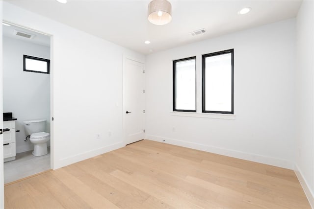 3001 E 51st St Unit 4, Austin, TX 78723 - unfurnished bedroom featuring light wood finished floors, connected bathroom, baseboards, and recessed lighting