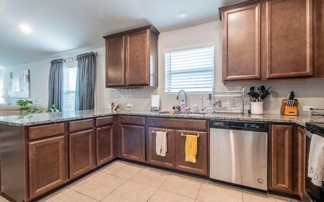 1678 Woodlands Dr, Kyle, TX 78640 - kitchen featuring appliances with stainless steel finishes, a peninsula, backsplash, light stone counters, and light tile patterned flooring