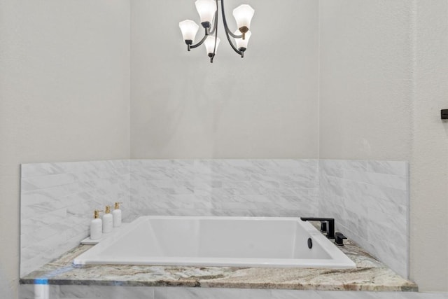 full bath featuring a chandelier and a bath