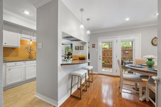 4159 Steck Ave Unit 162, Austin, TX 78759 - kitchen with healthy amount of natural light, light wood finished floors, white cabinets, a sink, and crown molding