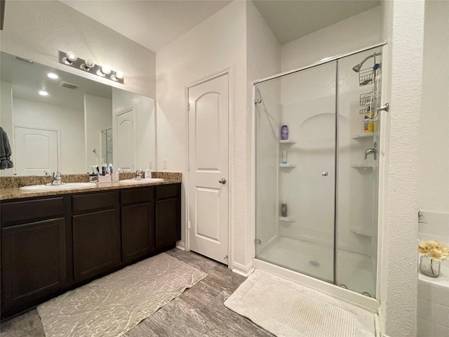 19900 Hubert R Humphrey Rd, Manor, TX 78653 - full bathroom featuring a shower stall, wood finished floors, and double vanity