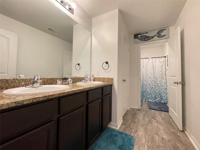 19900 Hubert R Humphrey Rd, Manor, TX 78653 - bathroom featuring wood finished floors, double vanity, and baseboards