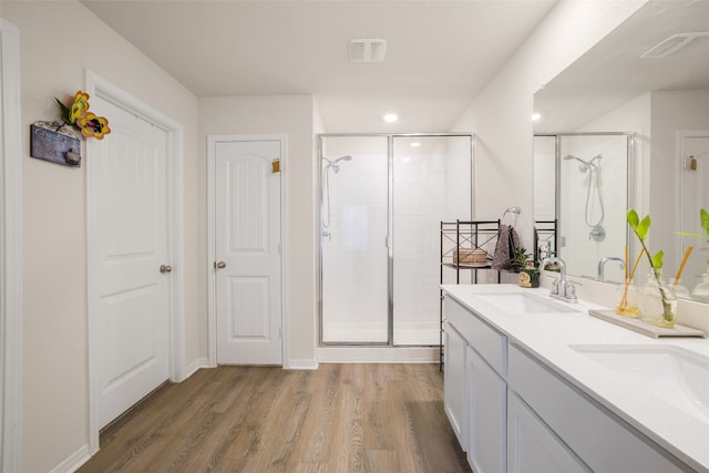 109 Egret Dr, Bastrop, TX 78602 - full bath featuring a shower stall, wood finished floors, double vanity, and recessed lighting