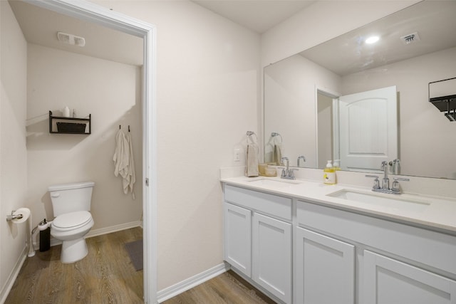109 Egret Dr, Bastrop, TX 78602 - bathroom featuring wood finished floors, toilet, double vanity, and baseboards