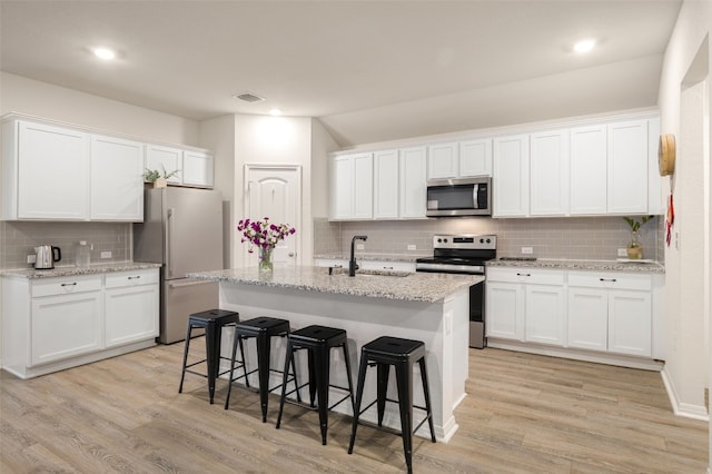 109 Egret Dr, Bastrop, TX 78602 - kitchen featuring stainless steel appliances, a sink, tasteful backsplash, white cabinetry, and recessed lighting