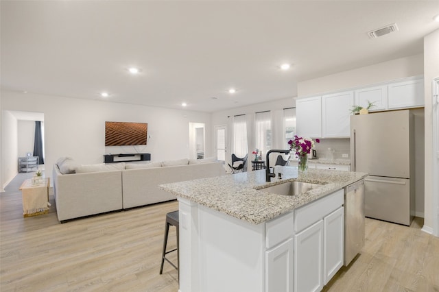 109 Egret Dr, Bastrop, TX 78602 - kitchen with a sink, freestanding refrigerator, stainless steel dishwasher, white cabinets, and light wood finished floors