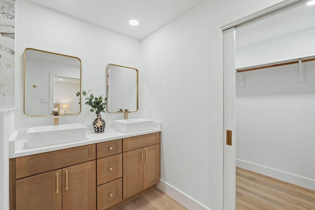 14806 Parco Path, Pflugerville, TX 78660 - full bathroom with wood finished floors, double vanity, baseboards, and a walk in closet